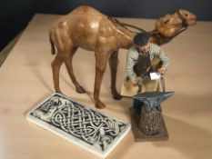 A handmade figure of a blacksmith, a leather figure of a camel in the style of Liberty,