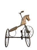 An antique child's pine and iron tricycle in the form of a horse.