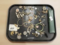 A collection of costume jewellery to include jadeite bangle, brooches, vintage whistles,