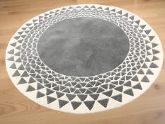 A machine made circular rug, diameter 152 cm.