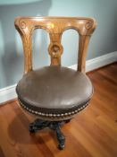 A late Victorian oak swivel desk chair on cast iron support.