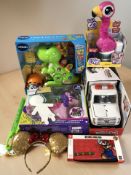 A group of modern toys including WWE Slambulance, VTech dinosaur toy, Nintendo Switch case, etc.