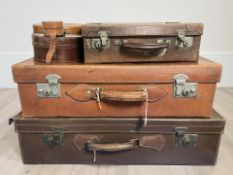 A group of stitched leather suitcases,