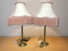 A pair of brass table lamps with tasseled shade, height 83 cm.