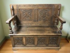 A 20th century carved oak storage monk's bench, width 123 cm.