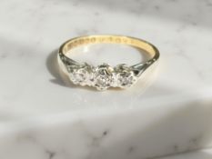 An 18ct yellow gold three stone diamond ring, size N. CONDITION REPORT: 2.