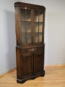 A 20th century glazed oak corner cabinet, height 182 cm.