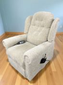 An electric reclining armchair in oatmeal coloured fabric