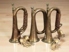 Three copper and brass bugles.