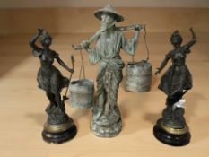 A patinated metal figure of a Chinese man carrying buckets,