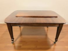 A Victorian style mahogany extending dining table with leaf and protective cover,