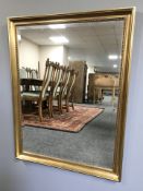 A pair of modern gilt bevelled rectangular mirrors, each 112 cm x 87 cm.