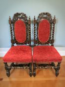 A pair of heavily carved oak hall chairs, width 48 cm.