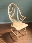 A pine spindle back elbow chair, the underside stamped 'Made in Slovenia'.