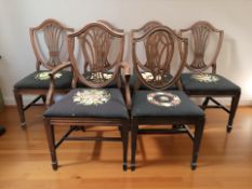 A set of six shield back dining chairs with tapestry seats, comprising five singles and one carver.