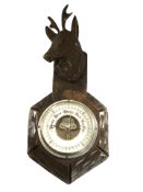 A Black Forest carved beech barometer surmounted by a stag, length 34 cm.