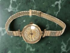 A lady's 1930's 9ct gold wristwatch on plated tri-colour metal bracelet