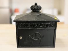 A painted metal letter box, width 38 cm.