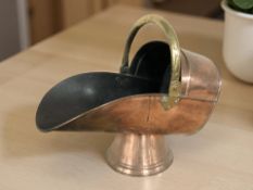 A Victorian copper swing handled coal helmet, length 50 cm.