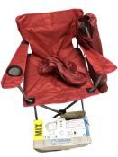 A halogen light in box and two folding outdoor chairs.