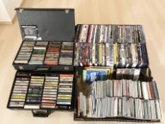 A collection of CDs, DVDs and cassette tapes.