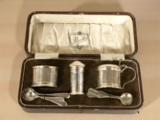 A silver cruet set in case, Reids, Birmingham 1928, three non-matching silver caddy spoons,