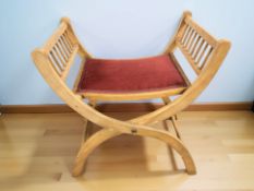 A 20th century X-framed piano stool.