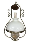 A brass hanging oil lamp with clear glass reservoir and opaque shade, 55 cm high.