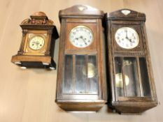 Two early 20th century oak wall clocks and a mantel clock.