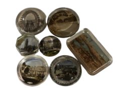 A group of glass and tourist paperweights.