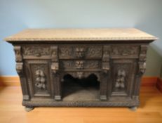 A late Victorian heavily carved oak sideboard with green man decoration,