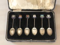 A cased set of six silver teaspoons with enameled Scottish crests.