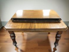 A Victorian mahogany extending dining table with two leaves,
