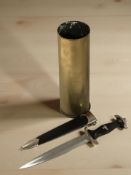 A reproduction German SS dagger in sheath, together with an inert brass shell casing.