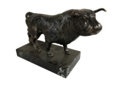 A contemporary patinated metal figure of a bull on marble plinth, length 31 cm.