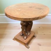 An Indian carved hardwood oval occasional table with elephant support, width 76 cm.