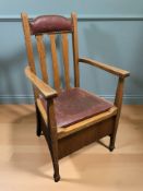 An Edwardian oak and studded faux leather armchair, width 61 cm.