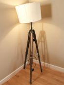 A teak and brass mounted tripod standard lamp, height 168 cm.