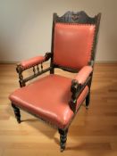 A late Victorian library armchair in red faux leather upholstery, width 70 cm.