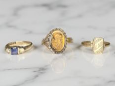 A 9ct gold three stone dress ring, a 9ct gold signet ring, and a tiger's eye cameo ring, unmarked.