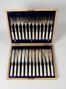 An oak canteen containing a twelve-place setting of EPNS and mother of pearl fish cutlery with