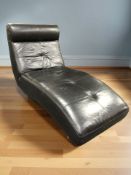 A contemporary stitched black leather lounger chair,