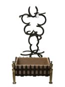 A horse shoe stick stand and a planter in the form of a fire basket.