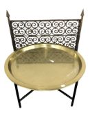 A brass topped circular table and a wrought metal fire guard