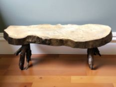 A rustic tree trunk coffee table, width 100 cm.