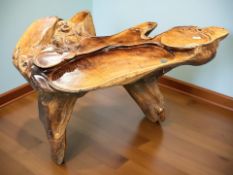 An oriental carved and lacquered rustic coffee table with Buddha carving, width 120 cm.