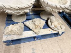 A concrete cherub wall pocket, width 37 cm, and two further similar ornaments.