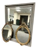 A contemporary over mantel mirror, 92 cm x 117 cm, and two gilt oval mirrors.