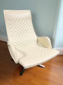 A contemporary De Sede beige leather swivel lounge armchair on chrome four legged support,