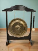 A late Victorian oak and brass dinner gong with beater, height 99 cm.